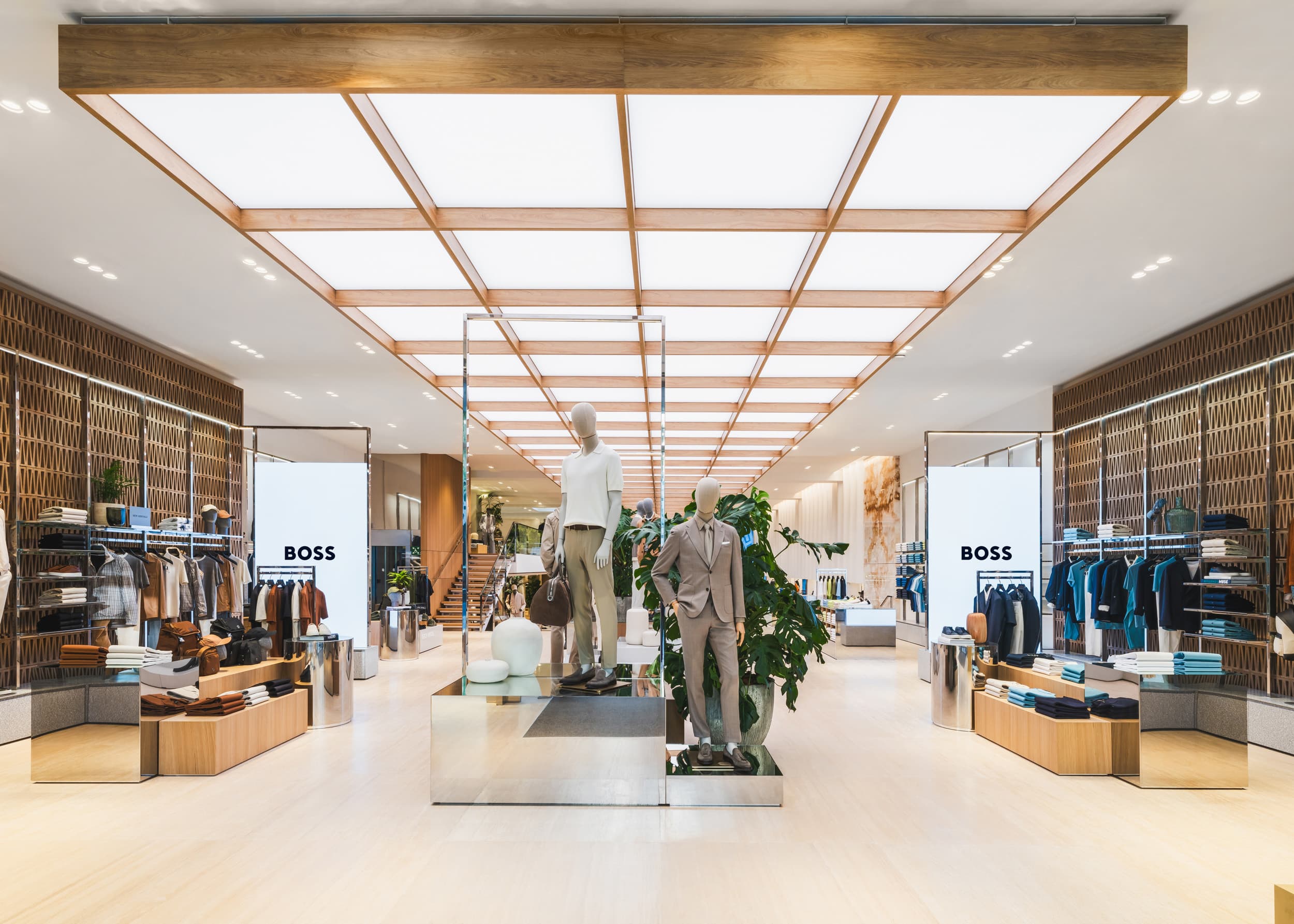 Hugo-Boss-Store mit zentralem Laufweg, Holzregalen und großem Rasteroberlicht.