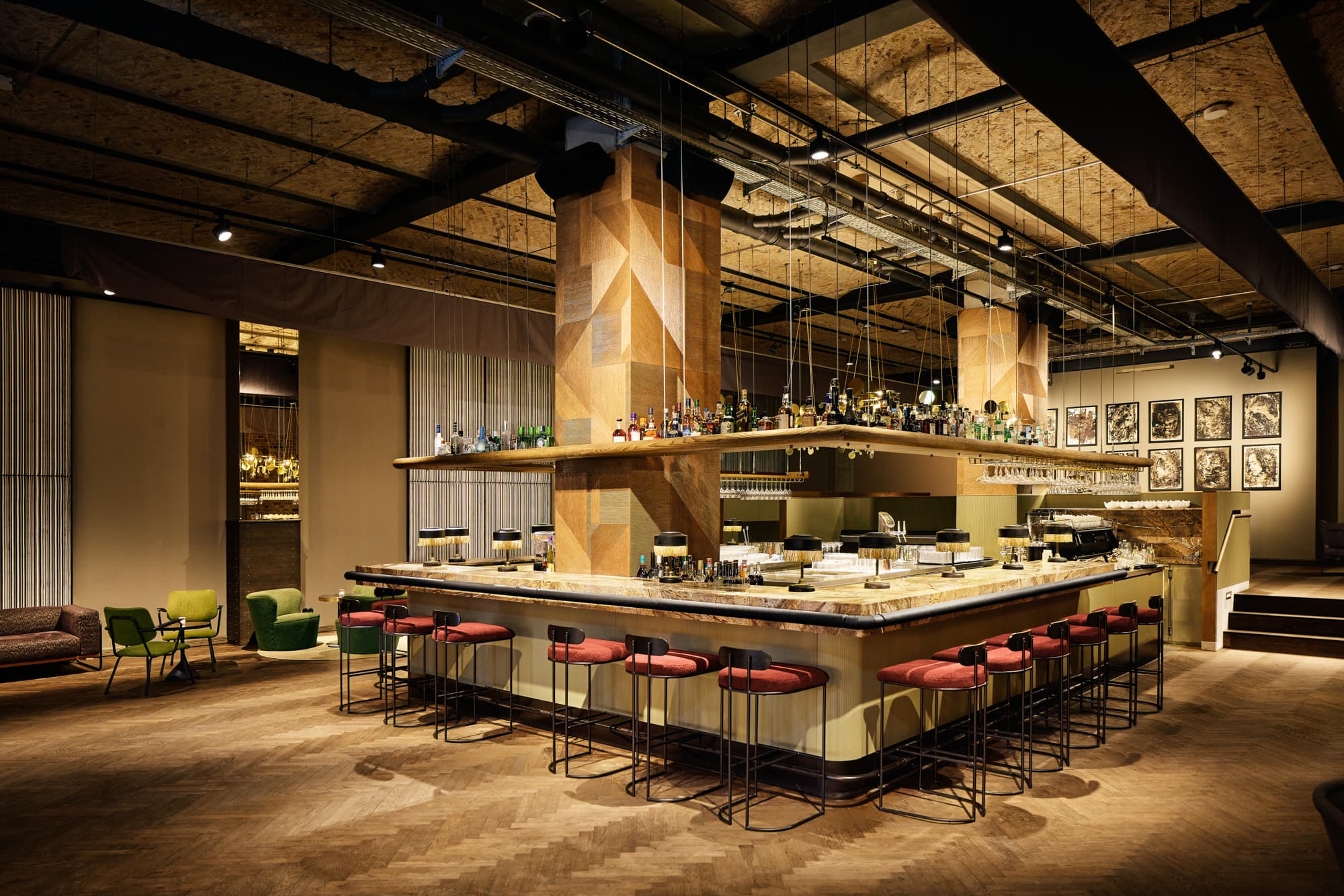 Offene Restaurantküche mit langer Theke, Barhockern und dunkler Decke.