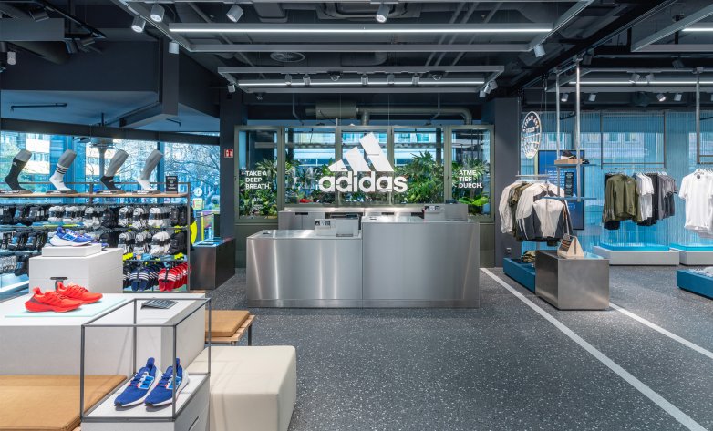 Offener Einkaufsbereich, Servicetheke mit Adidaslogo im Hintergrund