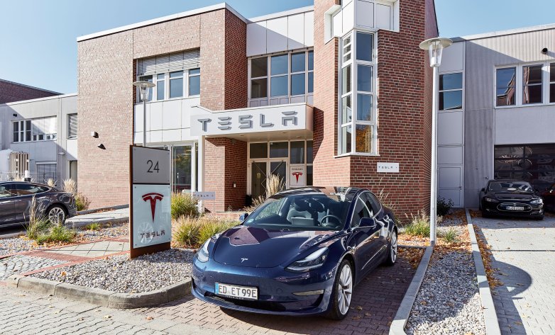 Blauer Tesla vor Tesla Serviceunternehmen in Kirchheim Aussenansicht