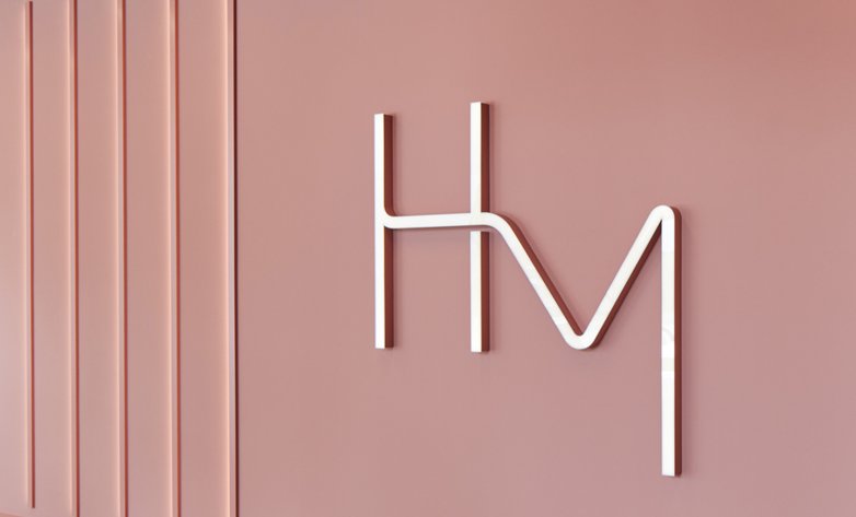 HdM Logo an Wand, daneben vertikale Leuchtelemente