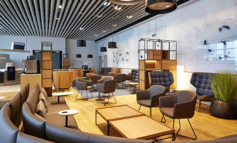 Lufthansa Lounge FRA, viele Sitzgelegenheiten und Infoschalter im Hintergrund