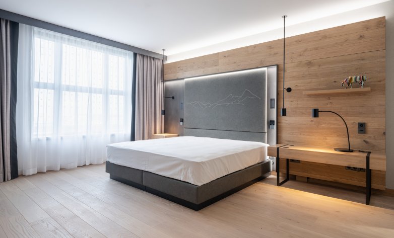 Schlafzimmer mit Eichenboden, Vinyltapete und Holztäfelung, inklusive Designmöbel - Hilton Munich Airport