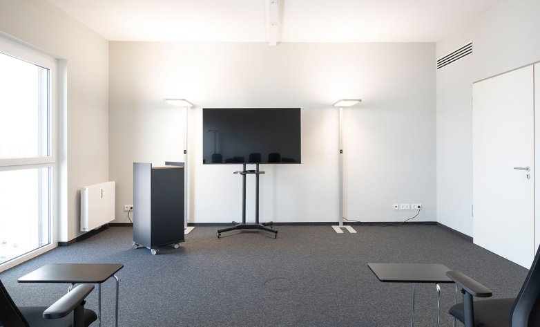 Großer Meetingraum mit Wandmontior, Lüftungsanlage, Designlampen. Der Raum ist mit edlen Teppichboden ausgelegt - Lucid