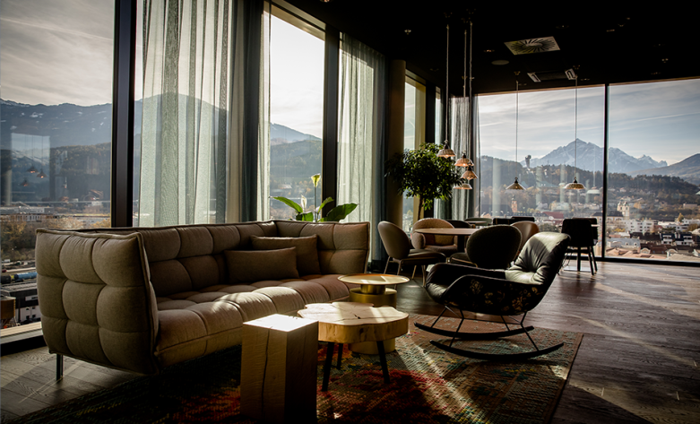 Luxeriöser Aufenthaltsbereich mit Desginmöbel, moderner indirekter Beleuchtung und Panoramablick - Motel One Innsbruck