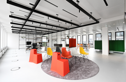 offener Empfangsbereich mit bunten Stühlen und Blick auf das Büro